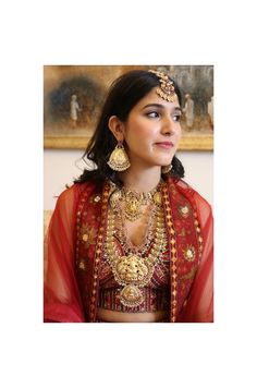 A beautiful Ruby Red South Indian bridal set in a traditional Goddess Lakshmi design to make heads turn! Unfold the euphoria of majestically embossed bridal jewelry set in an enticing temple design that will elevate your look. We bring this to you taking Inspiration from the traditions of weddings of Southern India!   The set comprises of 5 pcs. A long necklace, a small necklace, a pair of earrings and a tika.  Details: Long Necklace Length-13 Inches Choker Necklace Width at Centre with Pendant- Festive Lehenga With Intricate Design For Diwali, Anarkali Traditional Wear With Intricate Design For Wedding, Red Kundan Necklace For Navratri, Red Kundan Necklace With Tilla For Navratri, Bollywood Style Temple Necklace For Diwali Wedding, Bollywood Temple Necklace For Wedding And Diwali, Kundan Sets With Motifs For Puja, Festive Lehenga With Intricate Design For Festivals, Festive Lehenga With Intricate Design