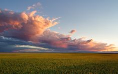 the sun is setting over an open field