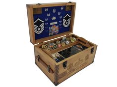 an open wooden box with buttons and medals in it on a white background for display