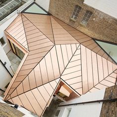 an aerial view of a building with copper roofing and brick walls, looking down into the courtyard