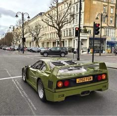 a green sports car is parked on the street