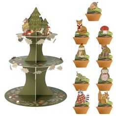 cupcakes are stacked on top of each other with animals and trees in them