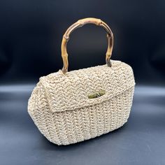 Add some retro flair to your outfit with this handbag. Bamboo handles make it look like you just came from a jungle adventure. * Straw like material  * Bamboo handles  * Gold clasp  * Secure closure  * Unique design  * Lightweight  * Made in Japan Handles show some wear and tear. Clasp has minor scratches. There is one teeny tiny stain inside. There are no other rips, tears, or stains. Please see the pictures for the full description. Vintage Bags With Detachable Handle, Vintage Beige Straw Bag For Travel, Retro Beige Bag With Top Carry Handle, Vintage Shoulder Bag With Round Handle For Everyday Use, Retro Beige Top Handle Satchel, Retro Summer Bag With Detachable Handle, Retro Summer Bags With Detachable Handle, Vintage Travel Bag With Round Handle, Vintage Beige Shoulder Bag With Handles