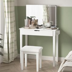 a white dressing table with a mirror and stool