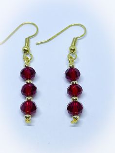 red glass beaded earrings with gold plated earwires on a white background