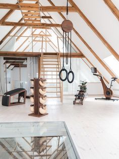 a room with wooden beams and various objects hanging from it's ceiling, including an exercise center