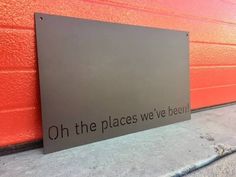 a sign that says oh the places we've been on it in front of a red wall