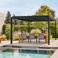 an outdoor dining area next to a swimming pool with chairs and table on the side