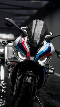 a motorcycle parked in a parking garage with rain on the windshield and headlamps