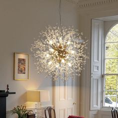 a chandelier hanging from the ceiling over a dining room table with four chairs