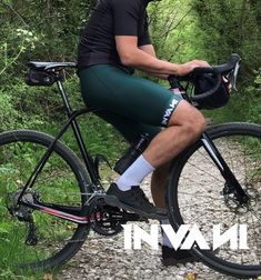 a man riding on the back of a bike down a dirt road