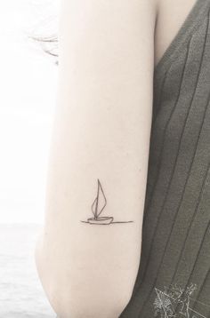 a small sailboat tattoo on the arm