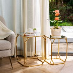 two side tables sitting next to each other in front of a window with flowers on them