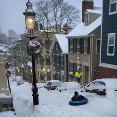 a person sledding down a snow covered street