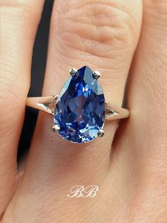 a close up of a person's hand with a blue ring on their finger