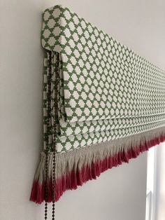 a green and white curtain hanging on the side of a wall