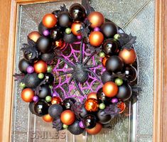 a wreath made out of black and orange ornaments