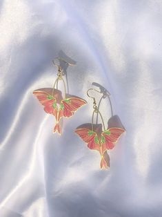 Shimmery shades of pink and green resin in a brass moth shaped setting. Golden hypoallergenic earring hooks are made of 925 silver-plated copper. Each piece is handmade and is created by carefully pouring and mixing resin into each individual section. This tedious process leads to beautiful vibrant colors that imitate a stained glass look in a much more durable and lightweight way. Every piece is naturally unique as it is impossible to maintain the pigment to resin ratio, leading to large variat Moth Earrings, Ethereal Jewelry, Art Deco Nails, Green Strawberry, Lafayette La, Jewelry Pins, Green Earrings, Hypoallergenic Earrings, Earring Hooks