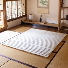 an empty room with tata mats and paintings on the wall, in front of a doorway