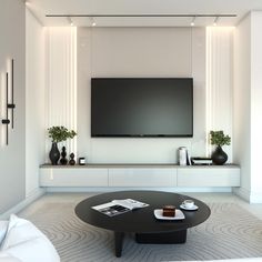 a living room with a large flat screen tv mounted on the wall next to a coffee table