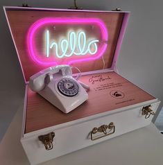 an open suitcase with a telephone in it and the word hello spelled out on top