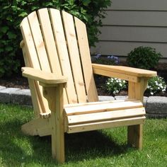 a wooden chair sitting on top of a lush green field