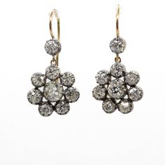 The Natalie earrings are inspired by the Victorian style. They center 2 old mine cut diamonds of K color and SI1 clarity that weigh 1.10ctw. The center stones are surrounded by 16 old mine cut diamonds of J/K color and VS2-SI1 clarity that weigh 2.70ctw. Earring measurement: 22mm by 14mm by 4mm Total weight: 5.0 grams / 3.2 dwt Victorian Diamond White Earrings With Diamond Accents, Antique Rose Cut Diamond Earrings In Diamond White, Antique Rose Cut Diamond White Earrings, Diamond White Rose Cut Drop Earrings, Victorian Style Diamond White Rose Cut Diamond Earrings, Victorian Rose Cut Diamond Earrings In Diamond White, Antique Single Cut Diamond White Earrings, Antique Diamond White Earrings With Single Cut Diamonds, Victorian Rose Cut Diamond White Earrings