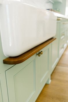 a large white sink sitting on top of a wooden counter