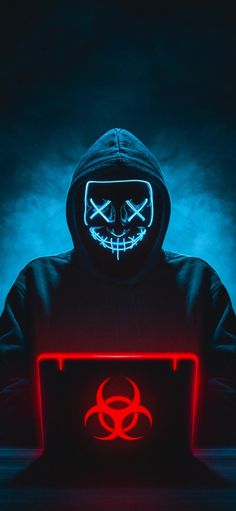 a person in a hoodie with a glowing laptop