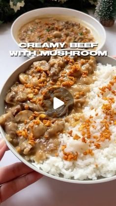 a bowl filled with rice, meat and gravy on top of a table