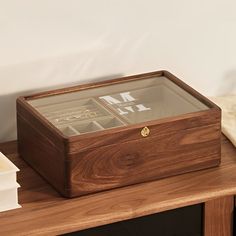 a wooden box sitting on top of a table next to a clock and other items