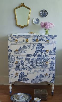 a blue and white dresser with plates on it