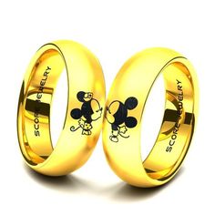 two gold wedding rings with mickey and minnie mouse on the inside, one is engraved in black