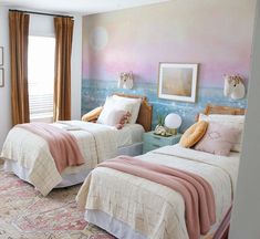 two beds in a room with pink and blue walls