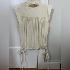 Unworn Isabel Marant White Sleeveless Blouse With Fringe Side Tie Detail. 100% Silk Sleeveless Tops With Drawstring Tie, Elegant Summer Tops With Drawstring Tie, Fitted Sleeveless Top With Drawstring Tie, Cream Sleeveless Top For Daywear, White Silk Blouse, White Sleeveless Blouse, Tie Colors, White Sleeveless, White Silk