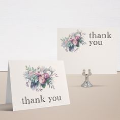 two thank you cards sitting on top of a table