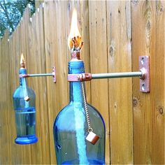 a blue bottle hanging from the side of a wooden fence with two lights on it