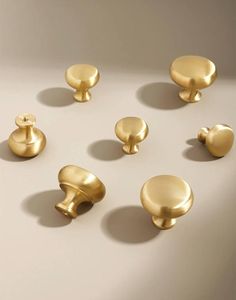 several brass knobs and handles on a white surface