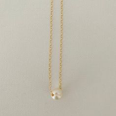 Just A Pearl! This simple yet elegant necklace is part of my Just A Pearl collection. One single pearl dangles from a delicate gold necklace. It measures 16 inches and length and can be adjusted to 15 inches for choker length. Minimalist Pearl Charm Chain Necklace, Minimalist White Chain Necklace With Pearl Pendant, Simple Pearl Chain Necklace, Elegant Everyday Charm Necklace With Simple Design, Simple White Pearl Drop Necklace, Minimalist Pearl Charm Necklace With Round Pendant, Classic Gold Charm Necklace With Pearl Drop, Minimalist Pearl White Chain Necklace With Pearl Drop, Minimalist Pearl Necklace With Round Pendant