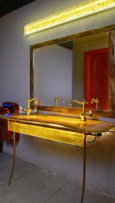 a bathroom with a large mirror and two sinks in the middle, along with a red door