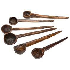 six old wooden spoons are lined up in a row