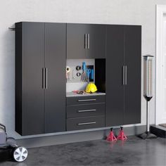 a garage with cabinets and tools on the floor in front of a wall mounted toolbox