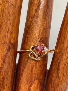 Heart shaped garnet gem set in yellow gold tone with one CZ accent stone.   Ring is in excellent condition without signs of wear or missing stones.   Mark inside is Hong Kong.   Size 9.5.   Packaged for gifting Garnet Gem, Green Peridot, Vintage Rhinestone, Stone Ring, Rings Statement, Beautiful Rings, Statement Rings, Garnet, Heart Ring