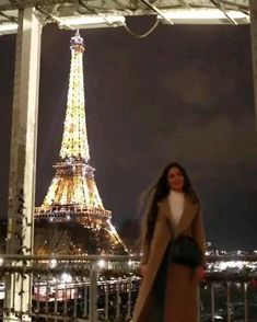 a woman standing in front of the eiffel tower