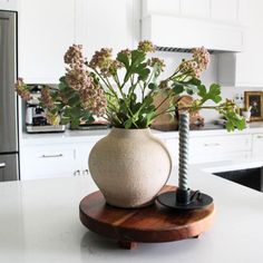 a vase filled with flowers sitting on top of a counter