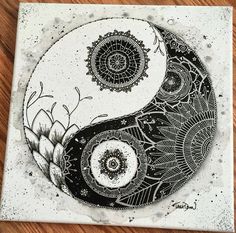 a black and white drawing of a yin - yang symbol on a wooden table top