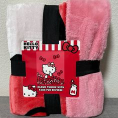 two hello kitty towels with tags attached to them, one is pink and the other is black