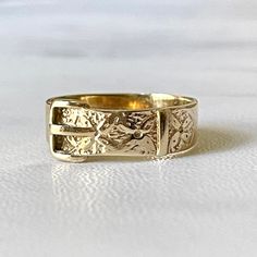 Vintage Buckle Ring 9kt. Yellow Gold Assayed in Birmingham  This buckle ring band is 9kt. yellow gold but looks like 14k. The color of the gold is just beautiful. It is smooth on one side and has a textured floral motif on the other. Assayed in Birmingham with full hallmarks.  It measures 5mm wide, size 7 1/2 (sizable) and is extremely comfortable. Can be stacked with other rings and would make a beautiful wedding band. The giving of a ring in the shape of a belt buckle began in Victorian times and was a symbolic token of the close relationship between the giver and the wearer. Hallmarks: Maker-RJC-   Size 7 1/2 sizable by jeweler 375- 9 kt gold Hallmarks-9-375-Anchor-U assayed in Birmingham  Packaged in a ring box ready for gift giving Free USPS shipping in the US Luxury Vintage Adjustable Engraved Ring, Engraved Yellow Gold Band Ring, Yellow Gold Engraved Band Rings, Adjustable Heirloom Engraved Yellow Gold Ring, Adjustable Yellow Gold Heirloom Engraved Ring, Adjustable Heirloom Yellow Gold Engraved Ring, Adjustable Yellow Gold Band Ring, Antique Adjustable Yellow Gold Rings, Heirloom 14k Gold Band Ring