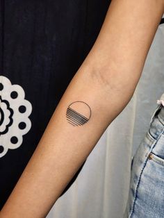 a woman's arm with a small tattoo on the left side of her arm