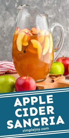 an apple cider sangria in a pitcher with apples around it